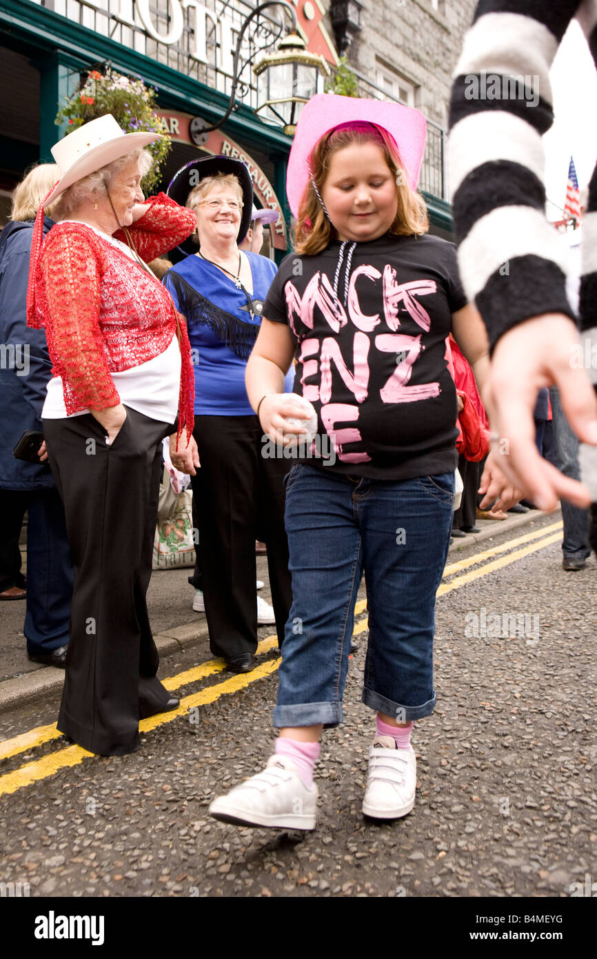 Young girl learning how to line dance step on street at Creetown Country Music Festival part of Gaelforce Stock Photo