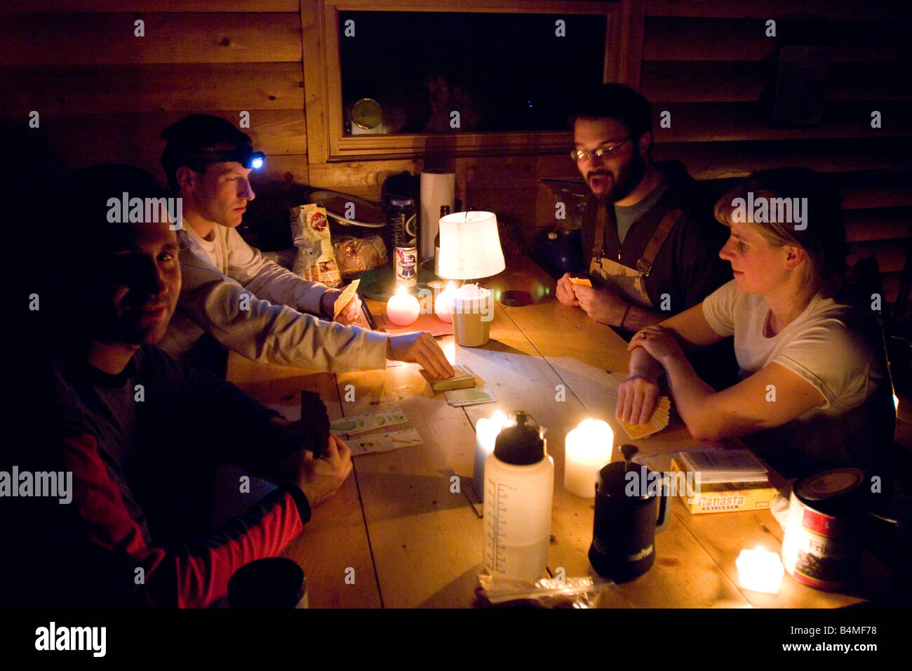 A Group Of Friends Play Games While Staying In A Rustic Cabin In