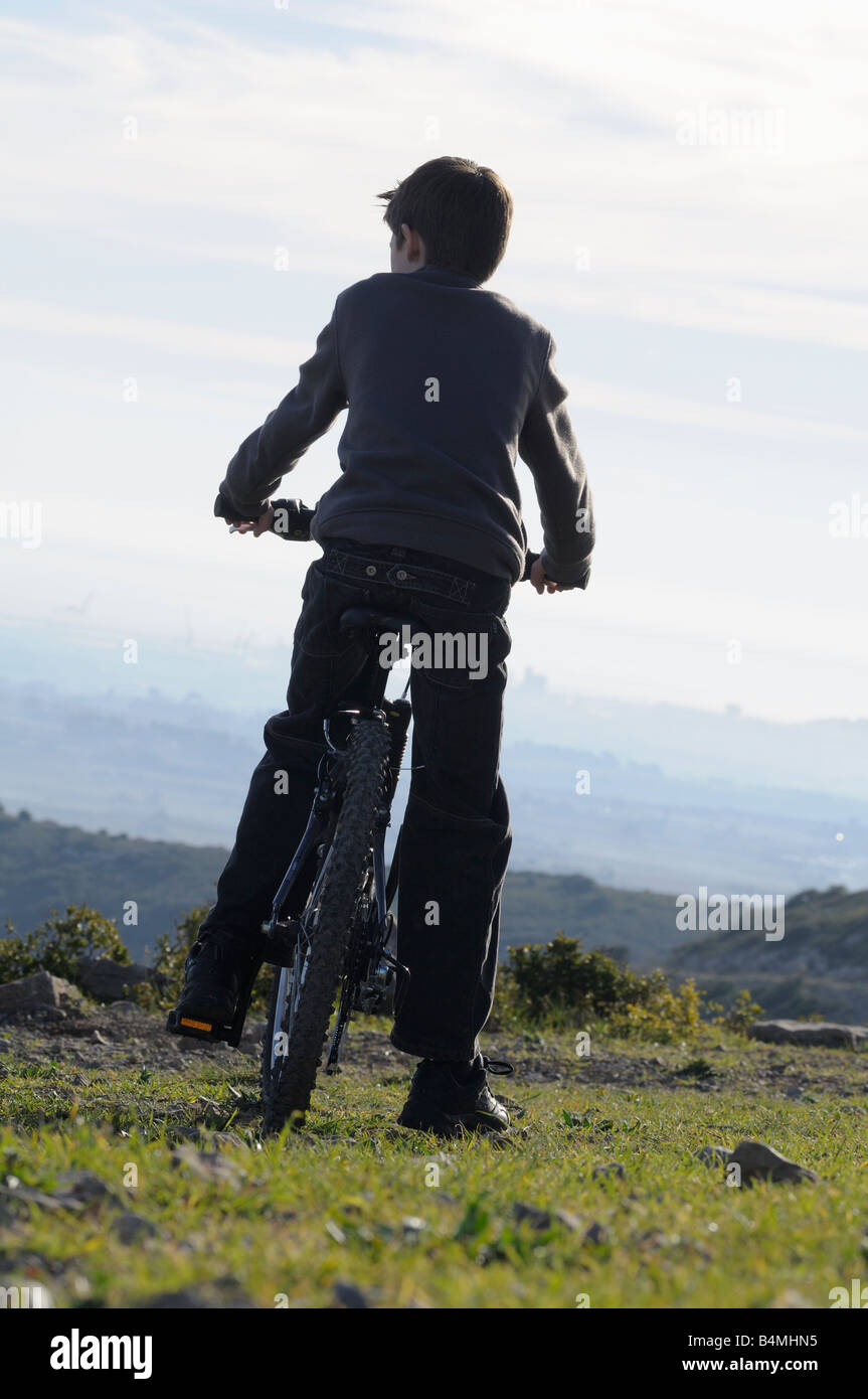 a child on his bike looking at the countryside. Stock Photo