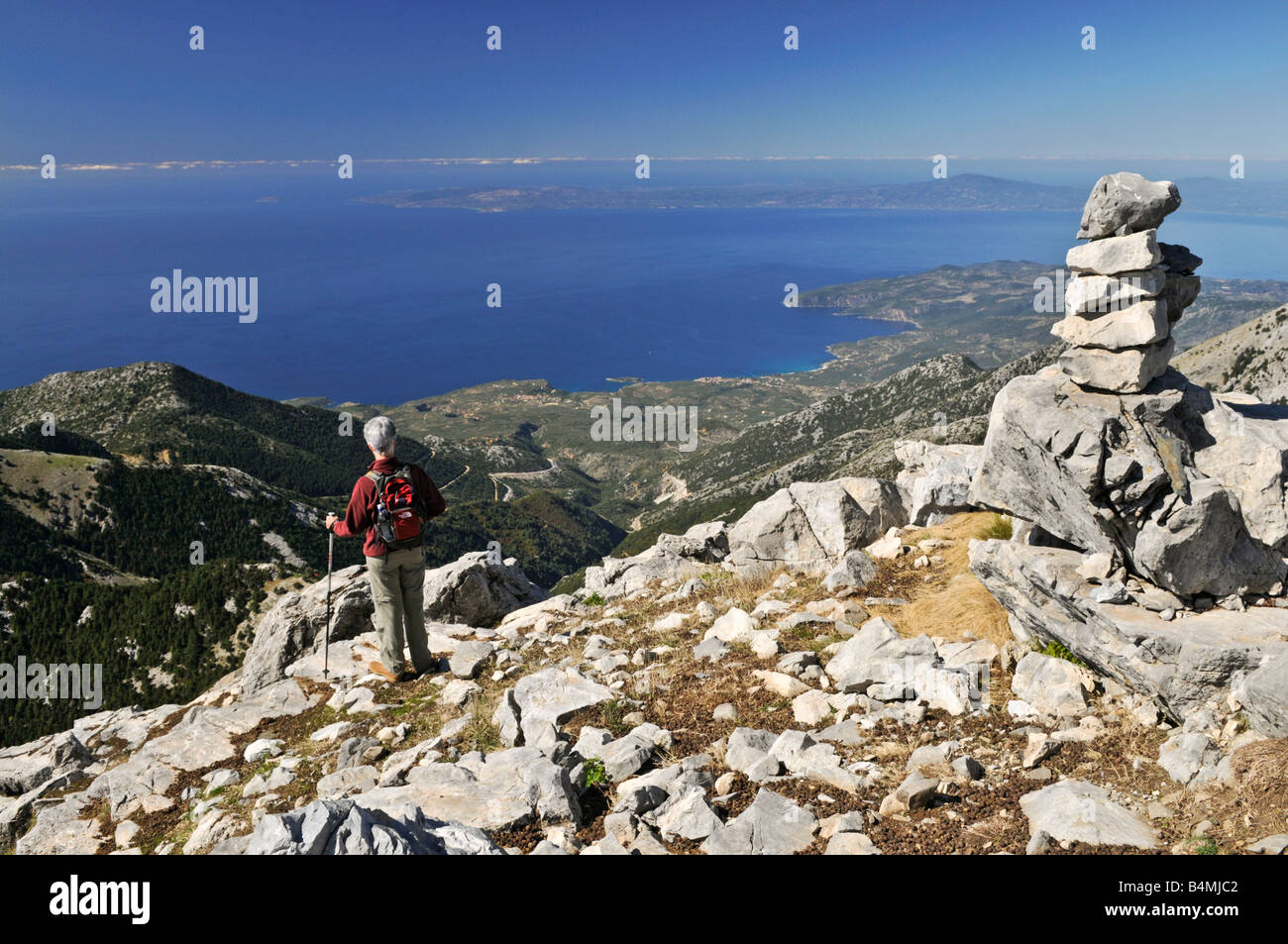 A walker in the Taygetos mountains looks down towards Kardamyli on the Outer Mani coast, Peloponnese, Greece Stock Photo