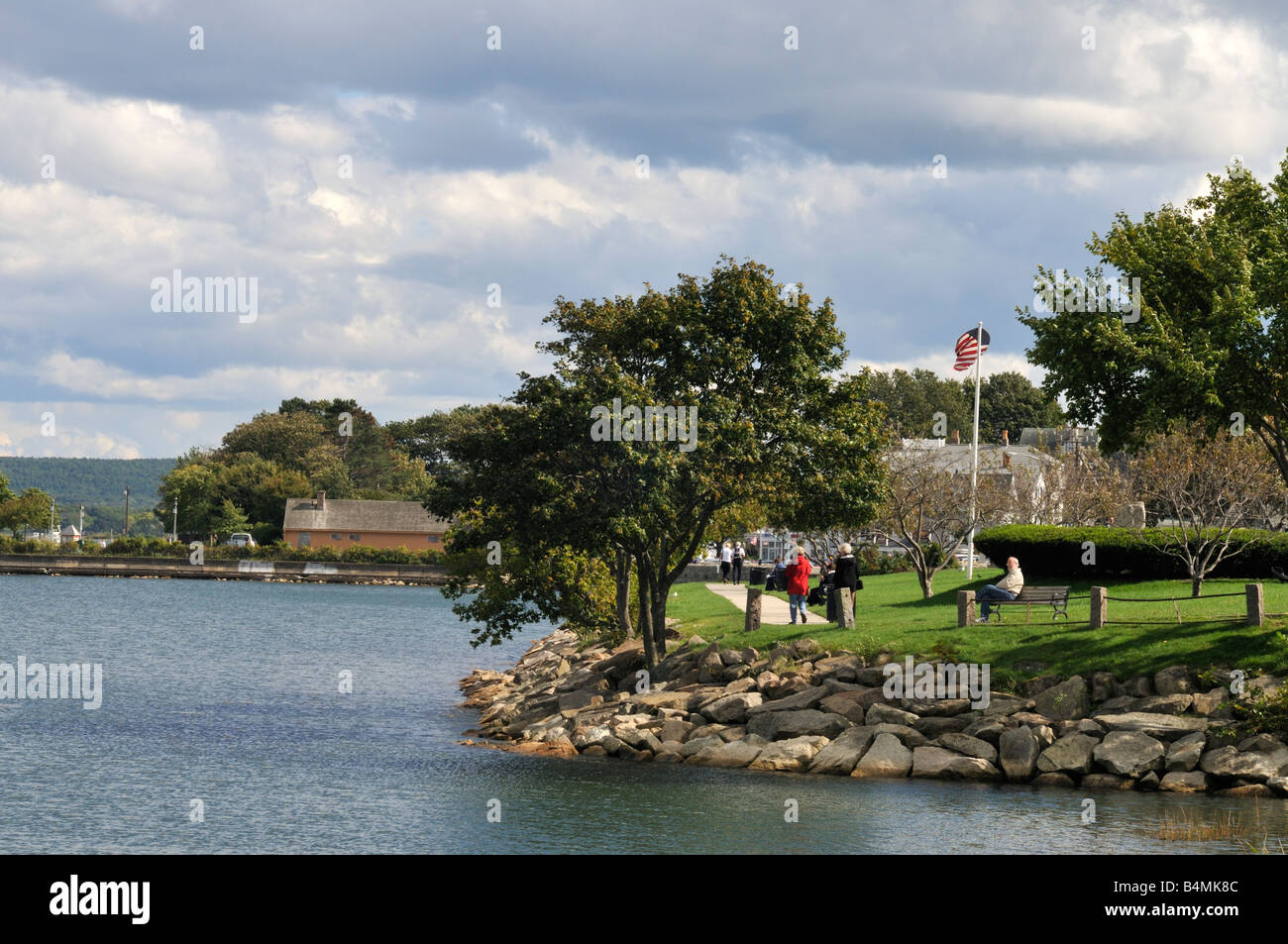 Waterfront park at historic Plymouth Harbor, MA, USA with people walking and sitting on park