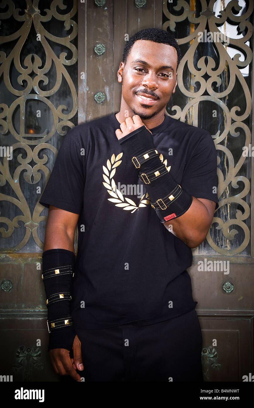 Stylish young black man wearing military style arm cuffs smiling at the