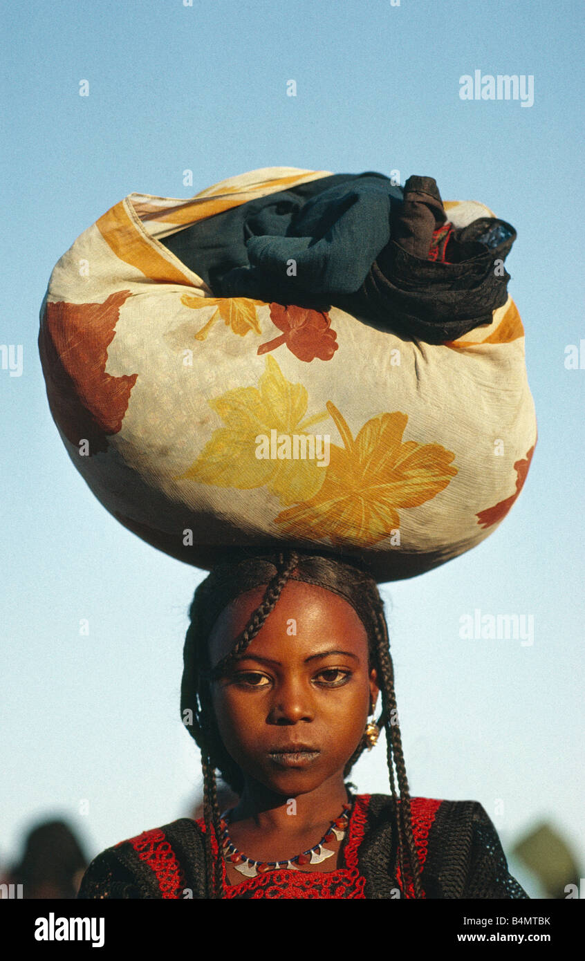 Niger, Agadez, Sahara desert, Girl of Tuareg tribe trasnporting cloth on head Stock Photo