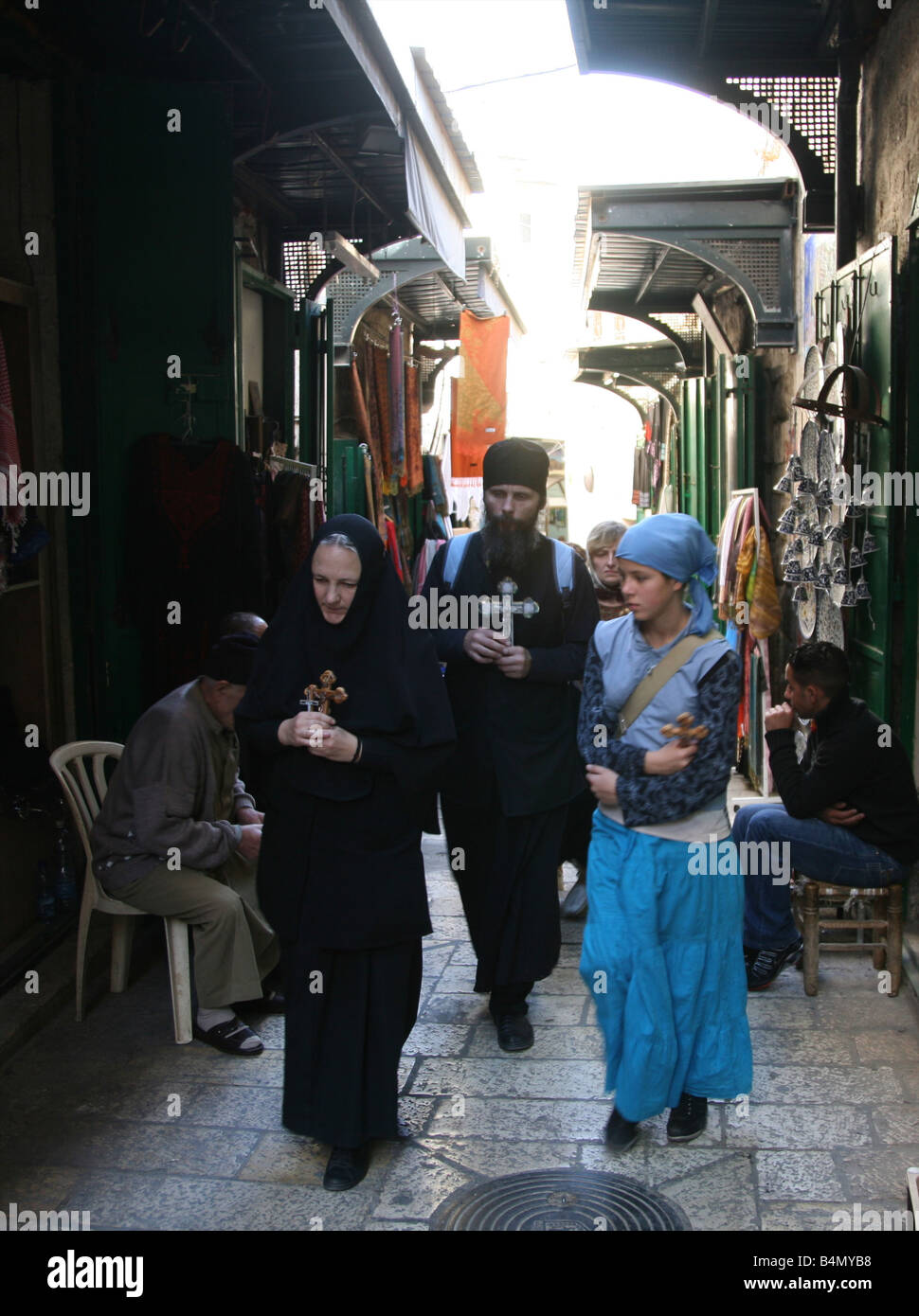 A group holding crosses walks through a market in the old city section of Jerusalem Stock Photo