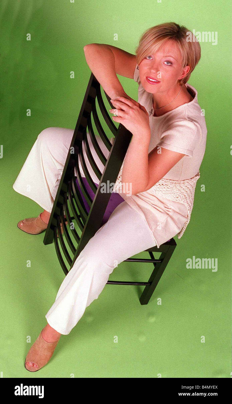 Kirsty Young TV Presenter Channel 5 sitting on chair wearing white trousers looking up June 1996 Stock Photo