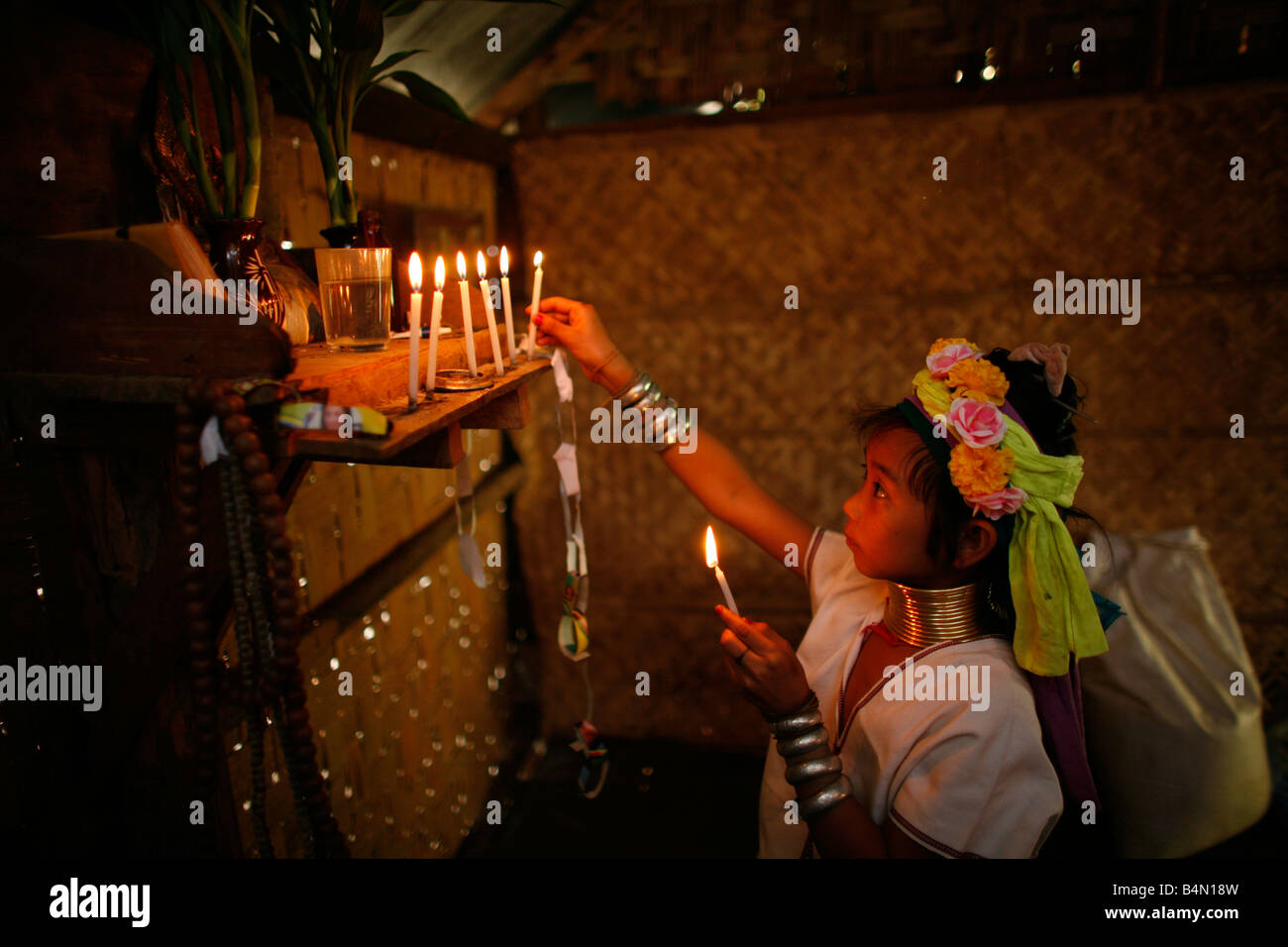 Long Neck Ritual A young Longneck girl lights candles at a home altar Approximately 300 ...