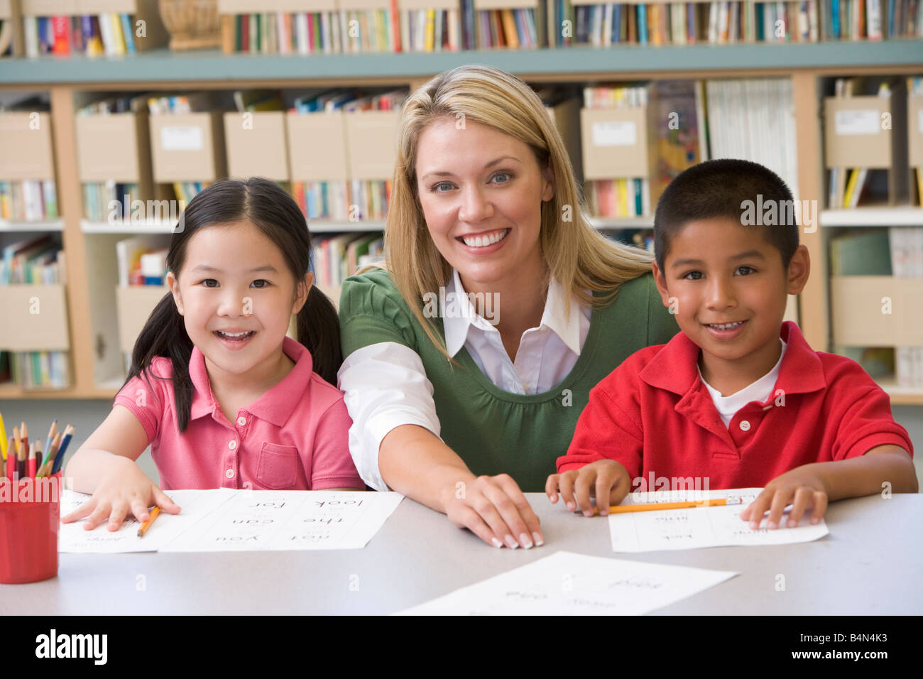 Two students in class with teacher Stock Photo - Alamy