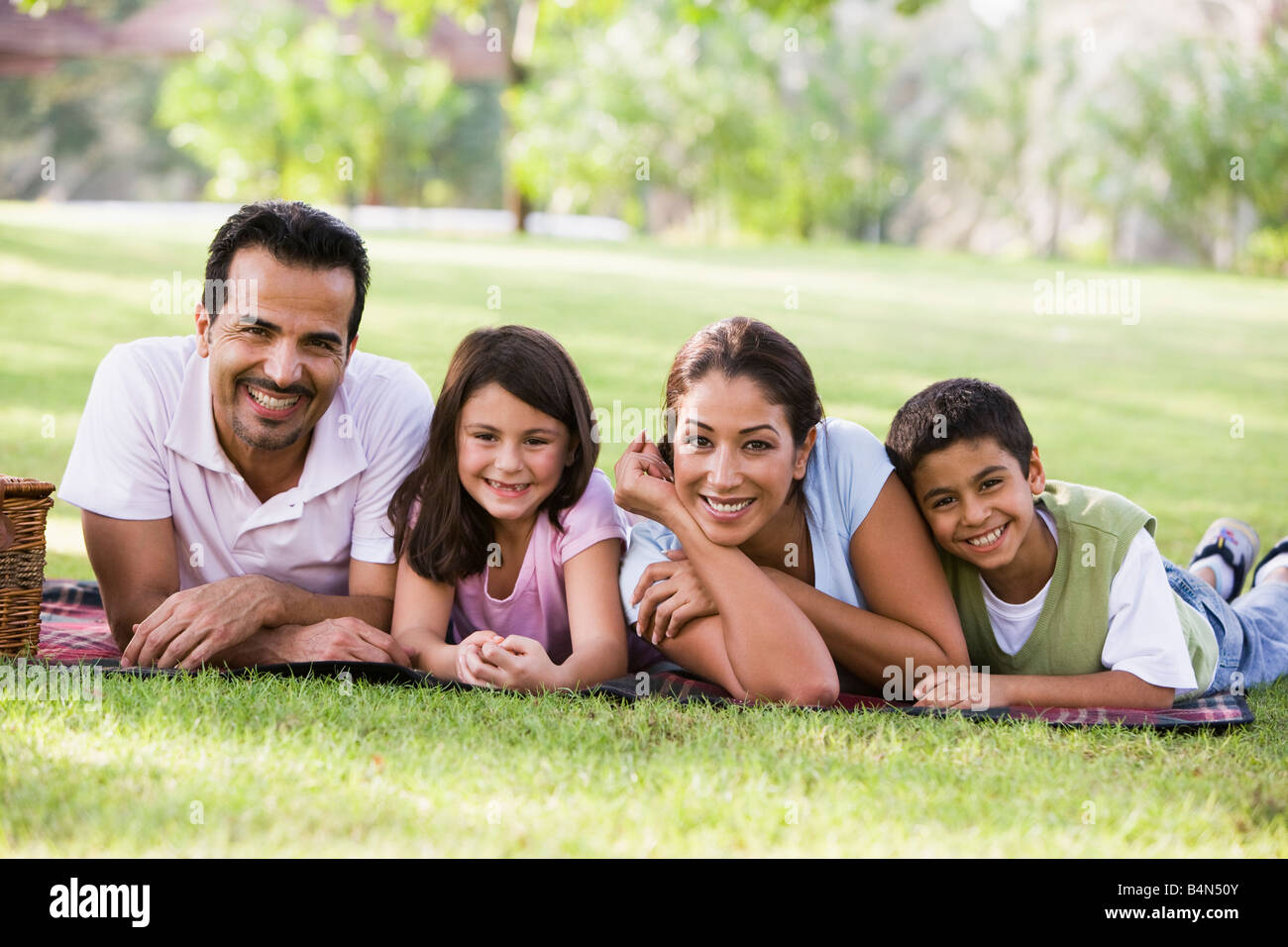 Family outdoors in park with picnic smiling (selective focus) Stock Photo