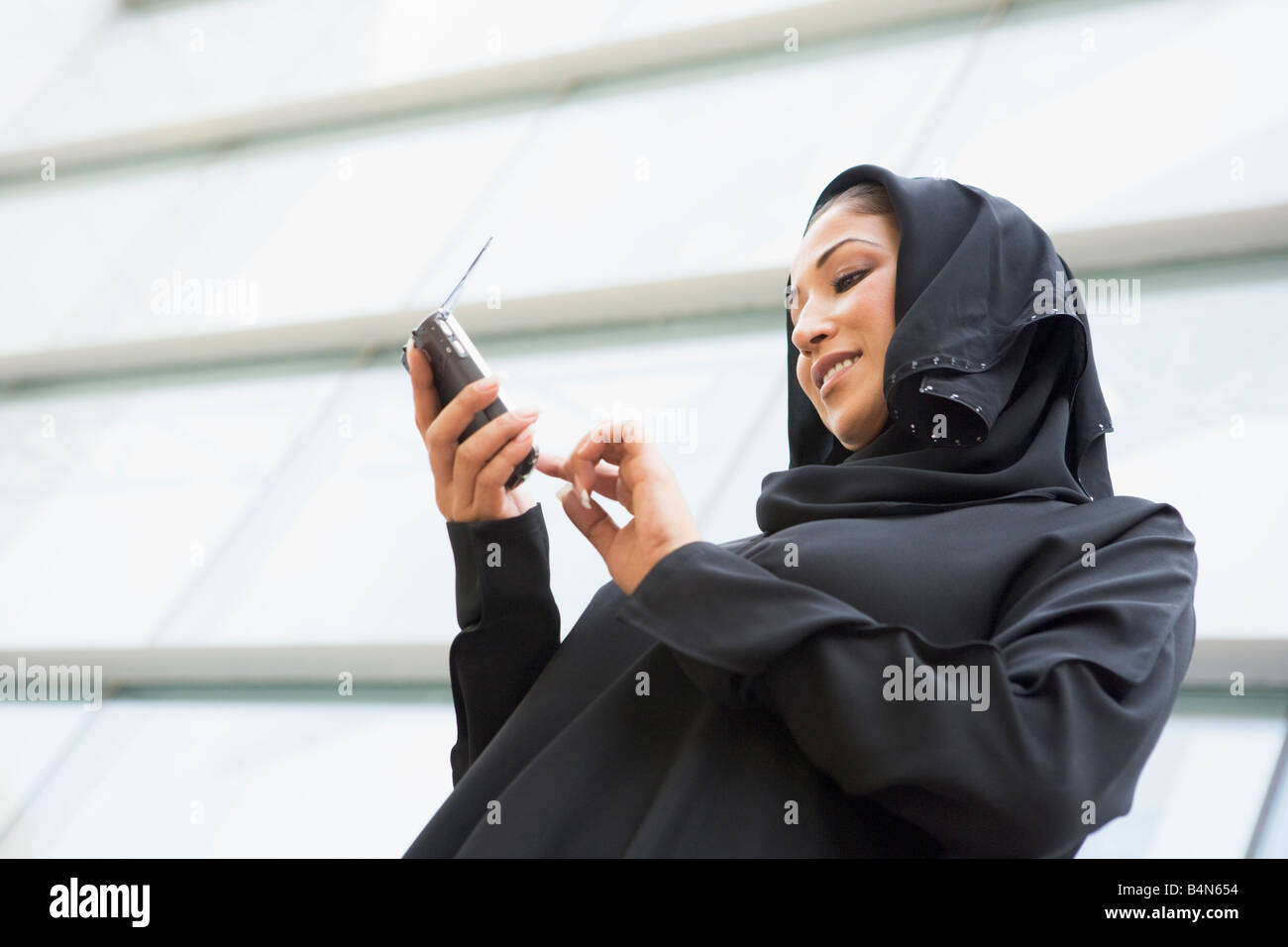 Businessman outdoors by building using PDA Stock Photo