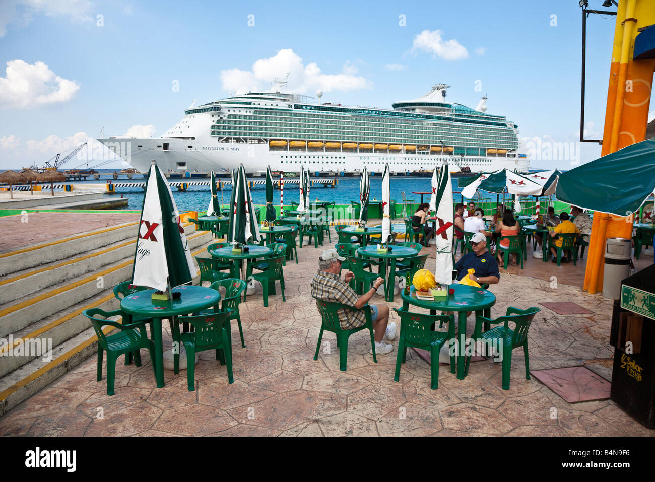 Men drinking at dockside bar in front of cruise ship in Cozumel Mexico Stock Photo