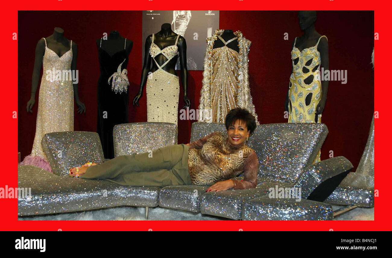 Dame Shirley Bassey donates half the proceeds from a Gala charity auction of 50 of her stage gowns to the Royal Welsh College of Music and Drama to create Dame Bassey Scholarships Pictured at Christies in London lying on a couch in front of a selection of gowns to be auctioned Stock Photo