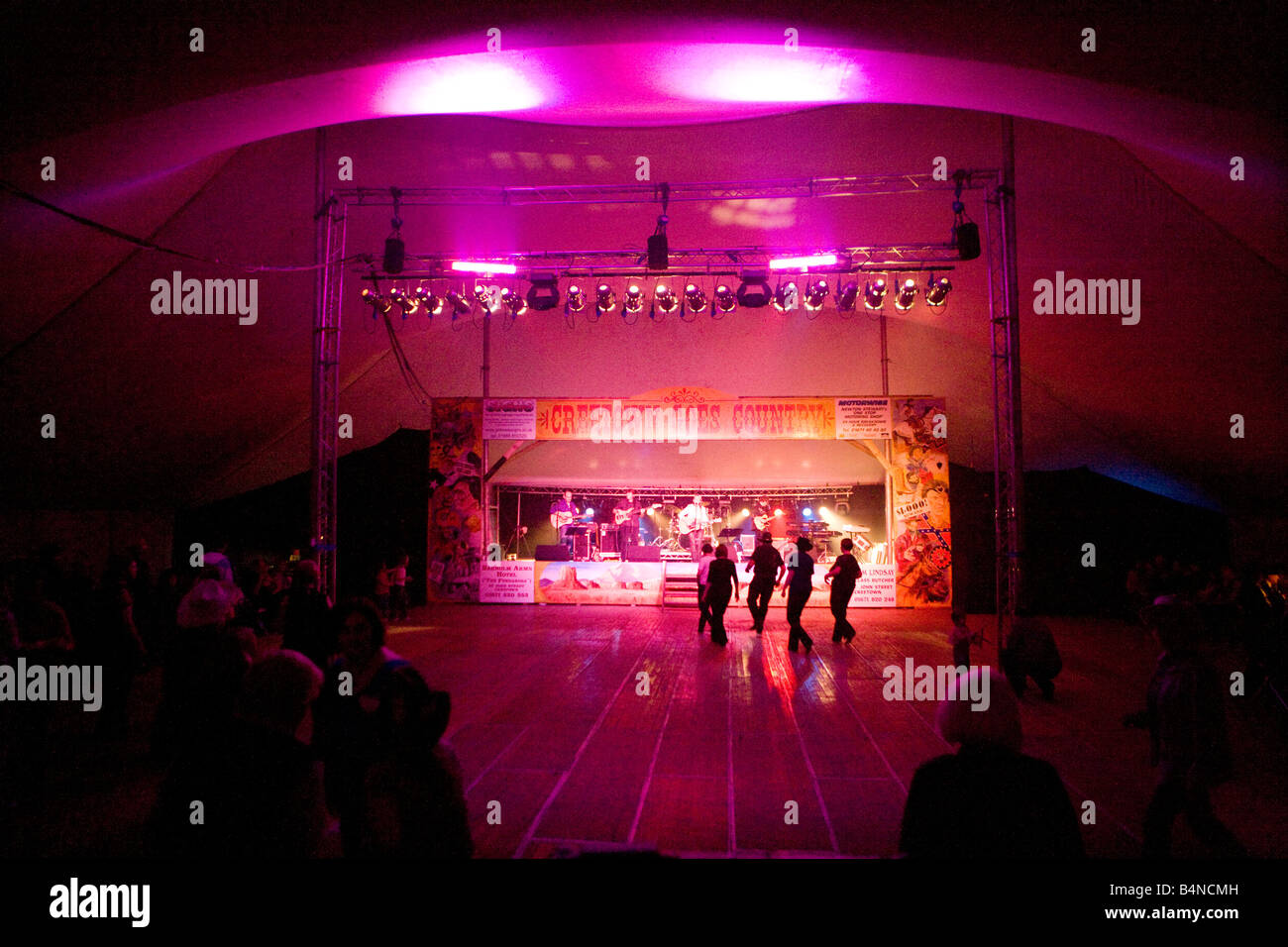 Gaelforce Creetown Country Music Festival dark night in tent silhouetted cowboys cowgirls line dancing near the stage Scotland Stock Photo