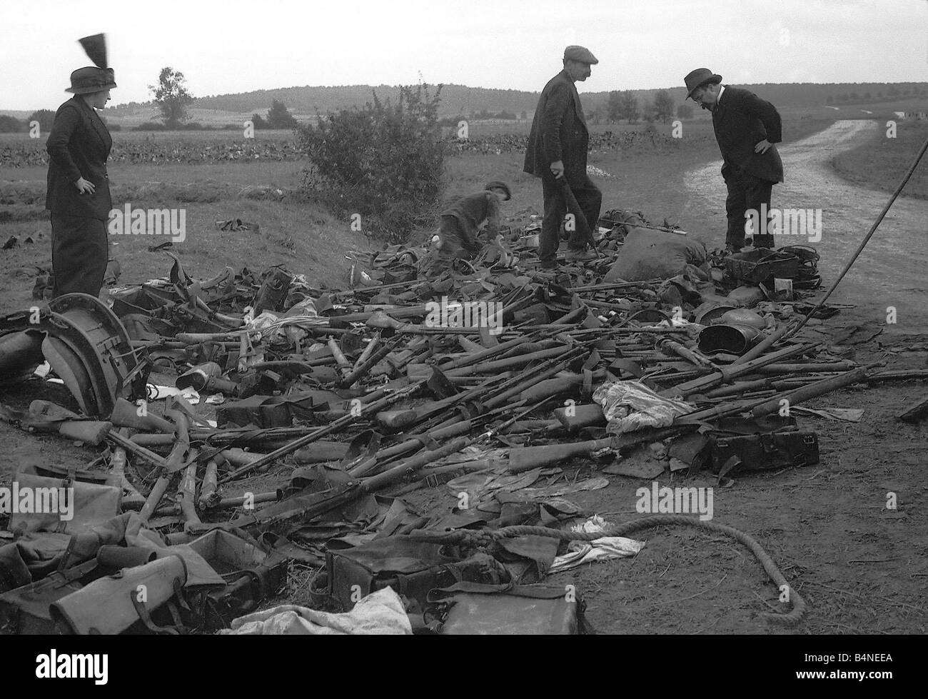 Civilians look at heap of rifles left in the field by the Germans during World War One Circa 1915 Stock Photo