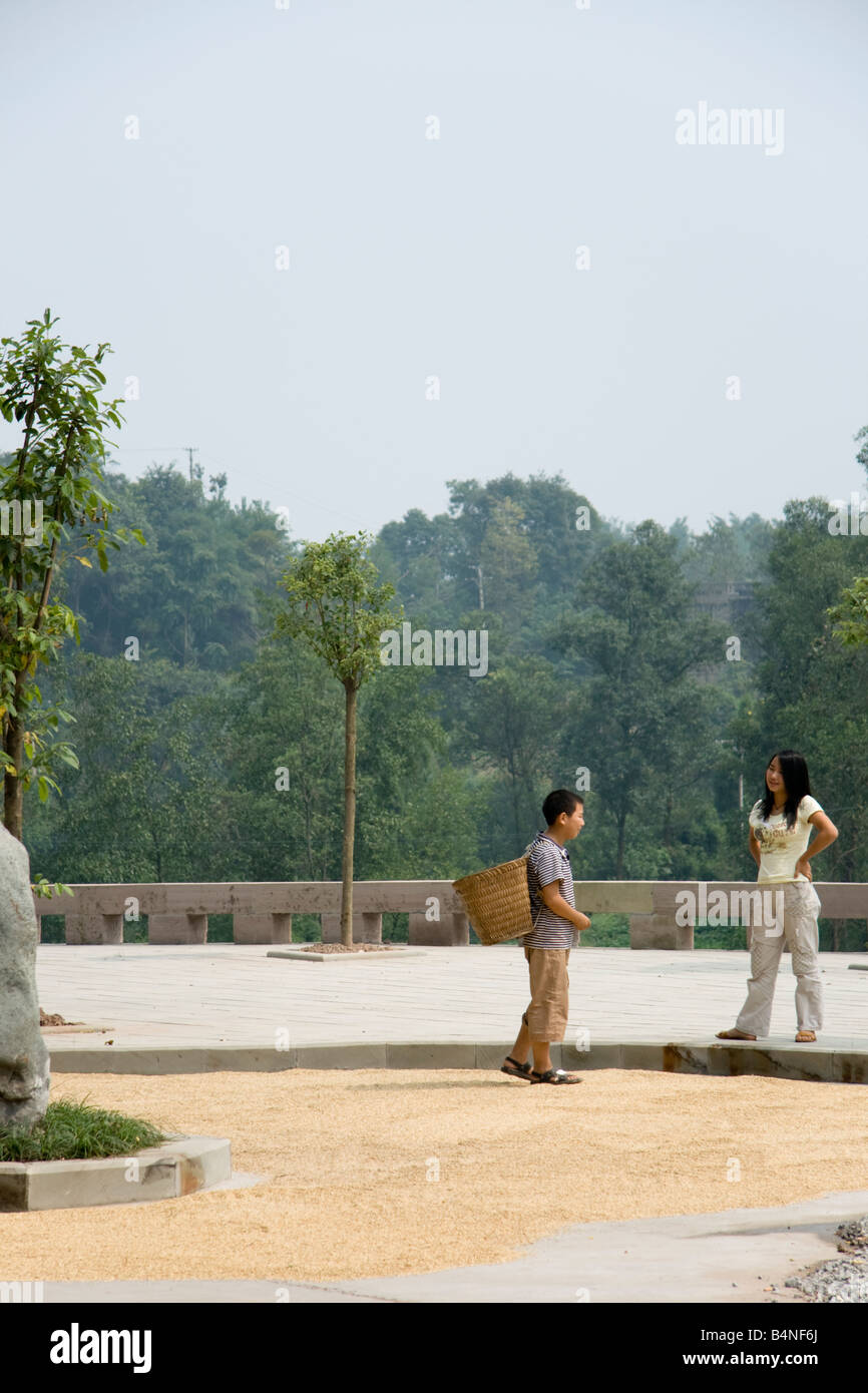 A Chinese boy carrying a basket in Dazu, China. The grain on the road ...