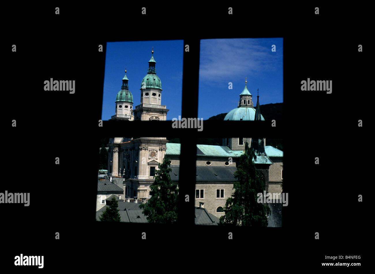 The dome and twin bell towers of Salzburg Cathedral, framed by a window overlooking the city's Old Town Stock Photo