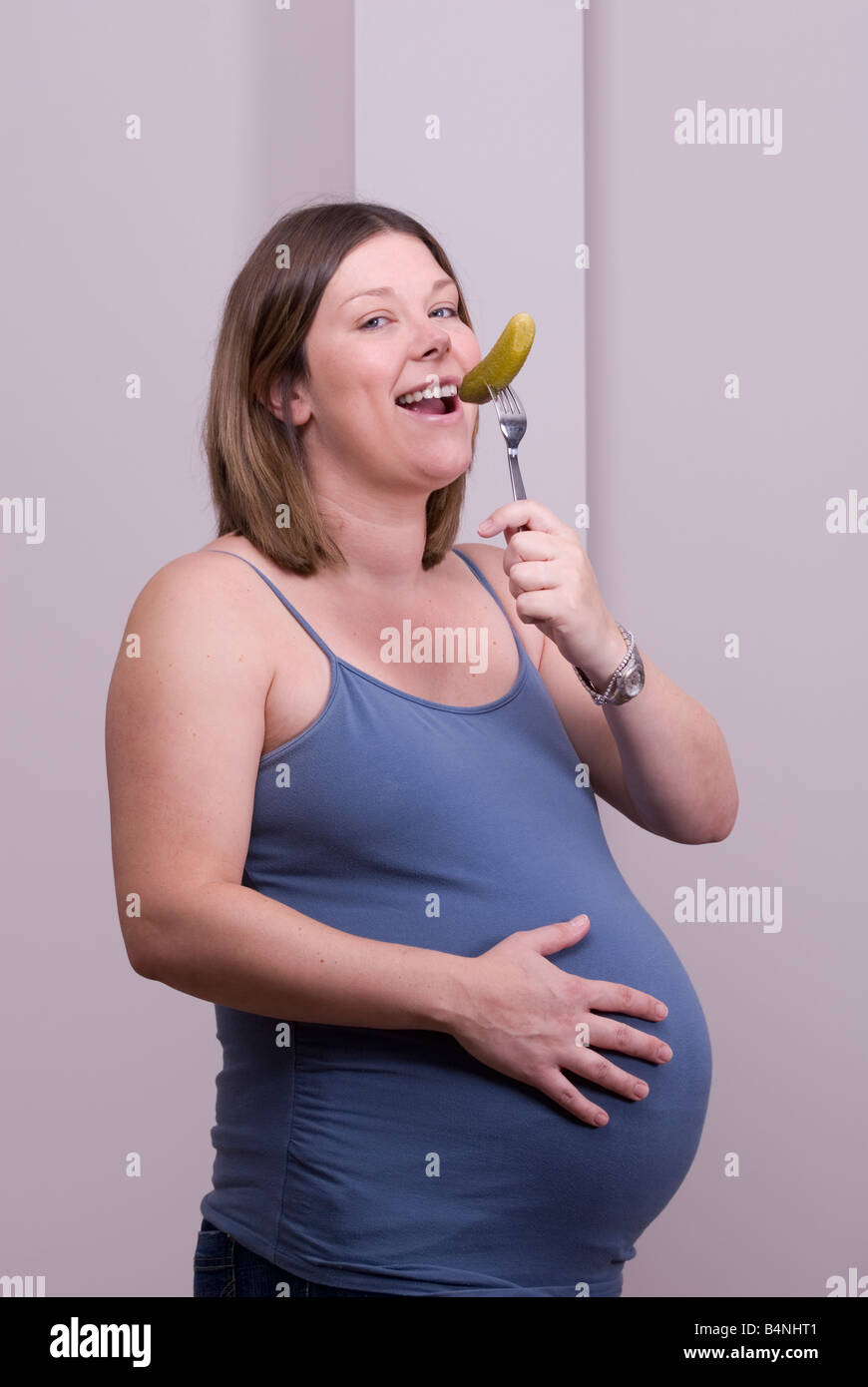 A pregnant woman eats a gherkin Stock Photo Alamy