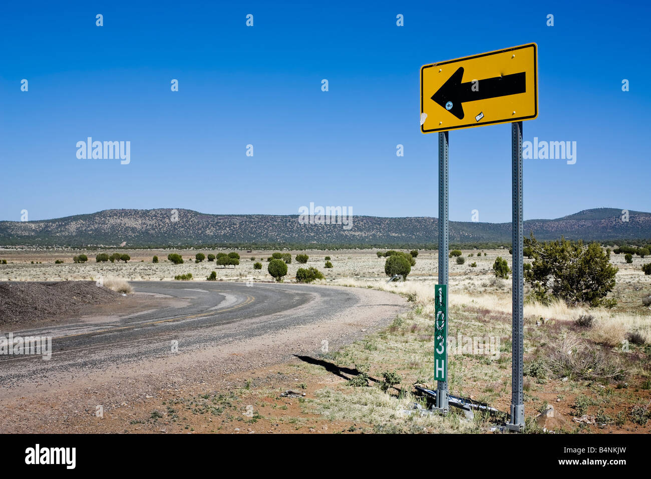 Yellow sign showing direction next to a road Stock Photo