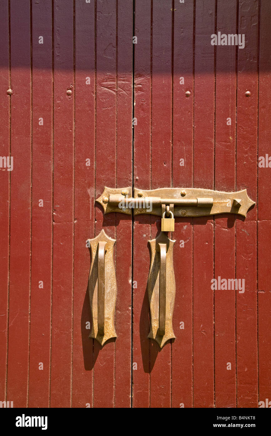 Red doorway with brass lock, padlock and handles on Hickson Road, The Rocks, Sydney, Australia Stock Photo