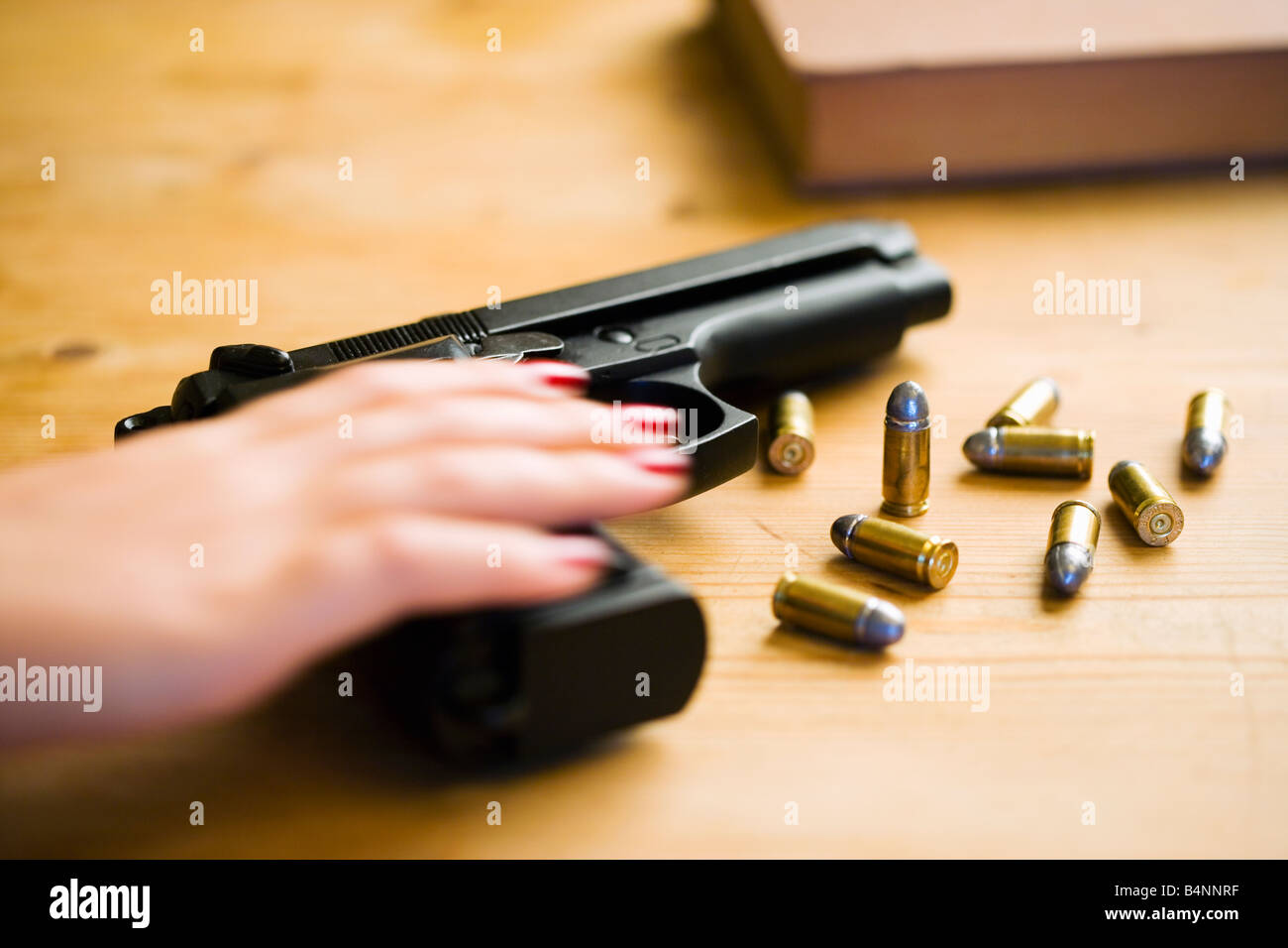 Hand reaching for Beretta 92F handgun with 9mm ammunition Stock Photo