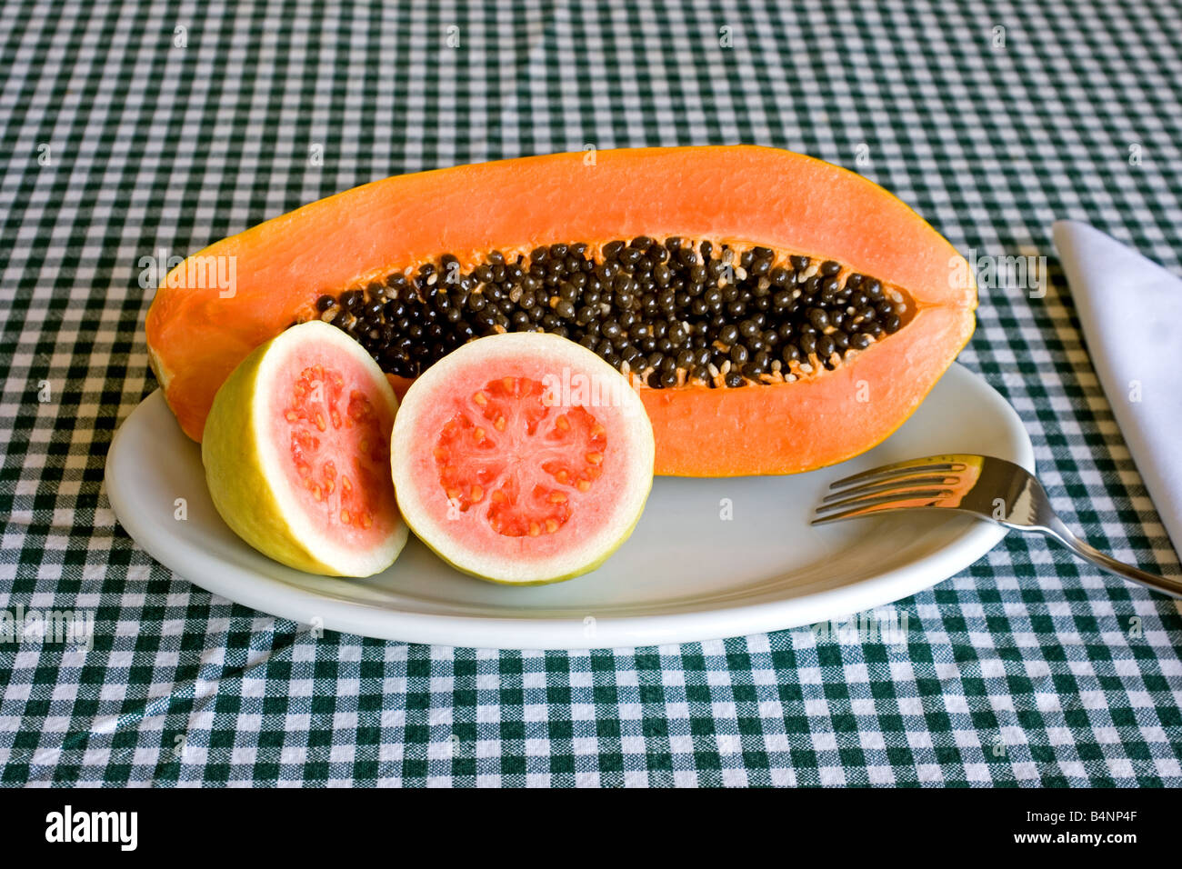Still life of papaya and guava on gingham Stock Photo Alamy