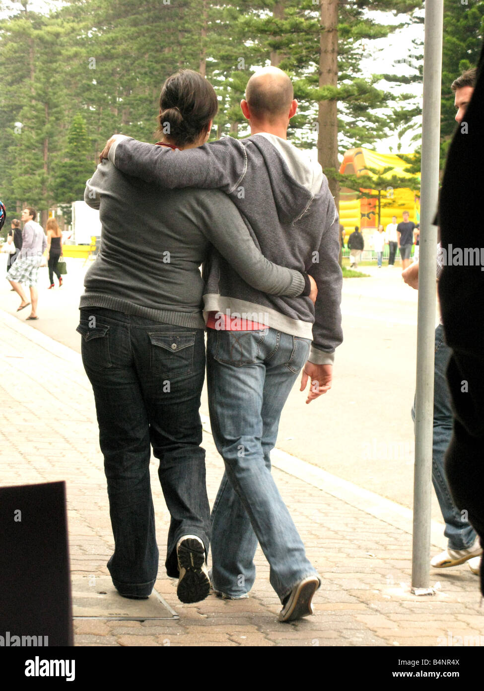 A man and woman embrace as they walk together Stock Photo