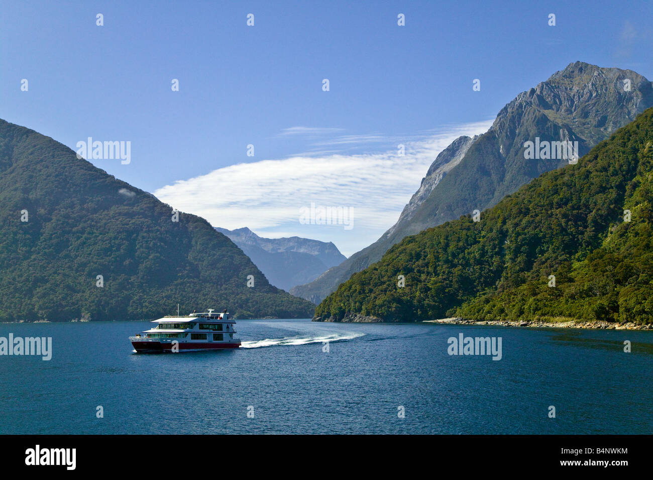 Sea entrance to Milford Sound, with a tourist boat in the foreground. South Island of New Zealand Stock Photo