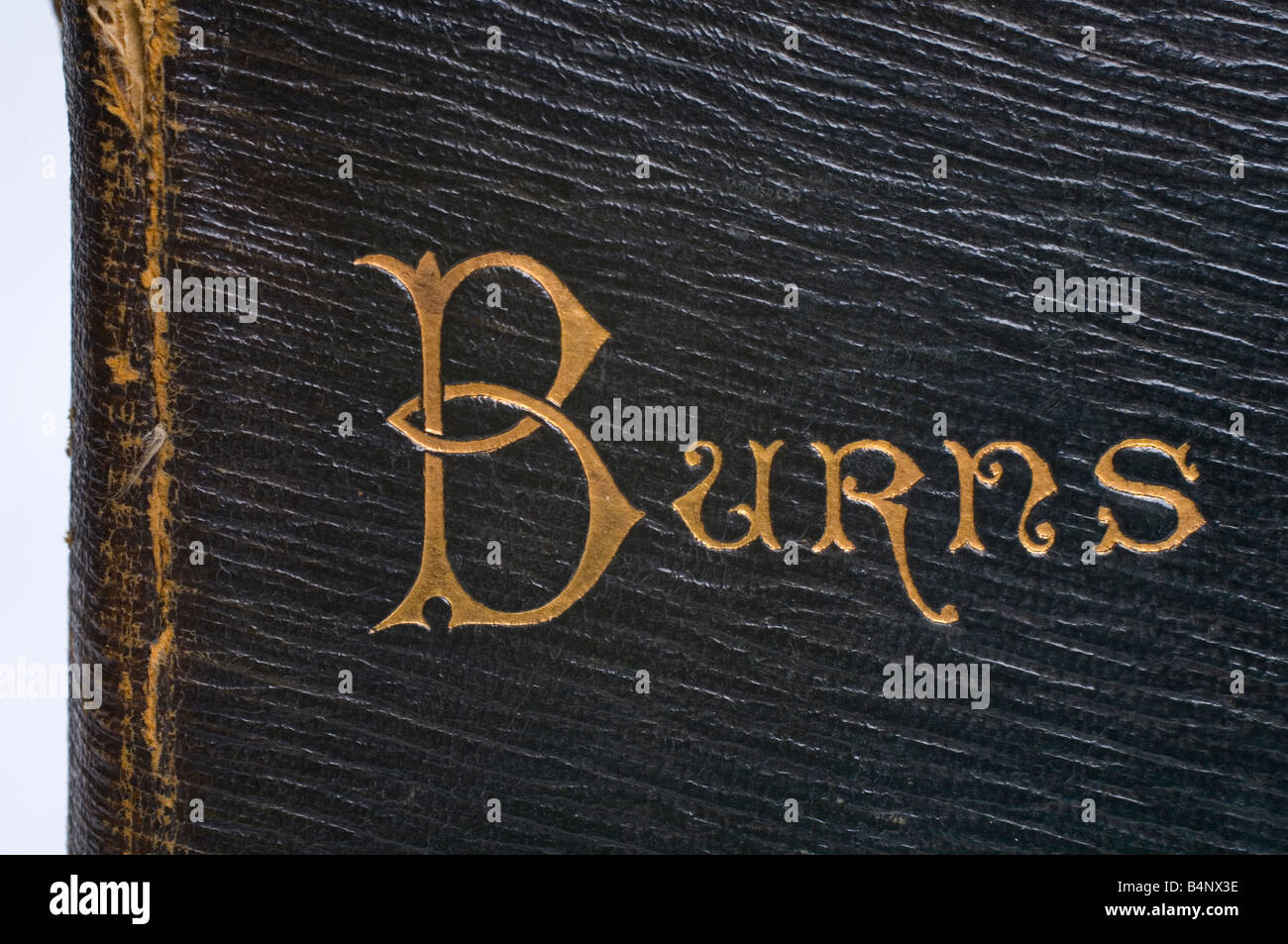 The name of the author Robbie Burns engraved in gold on the leather binding of an old book of his works Stock Photo