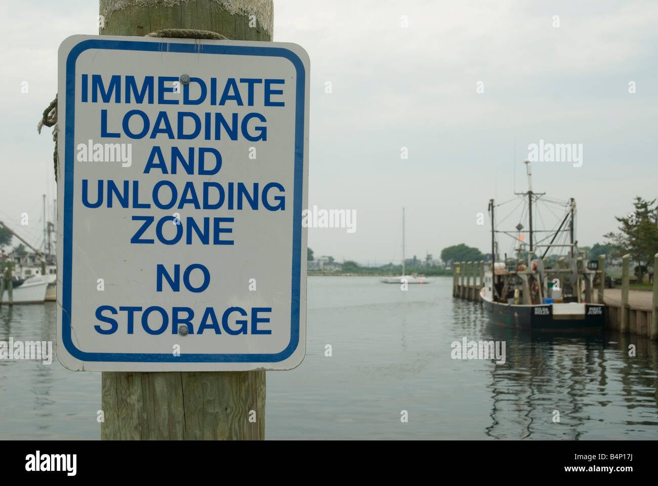 A sign tells fishing boats to load or unload from their boats here. No storage is allowed. Stock Photo