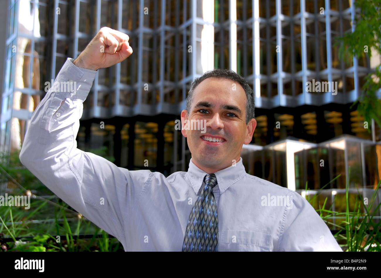 Triumphant businessman in the city raising an arm in victory Stock ...