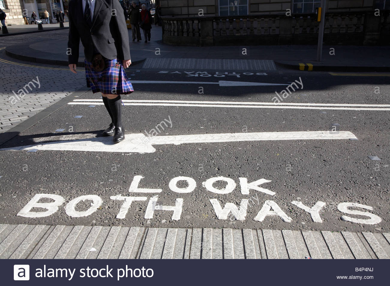 Look both ways sign on road with man in kilt Stock Photo