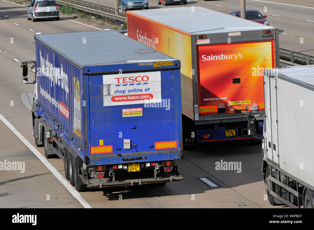 M25 motorway Sainsburys lorry overtaking a Tesco lorry Stock Photo Alamy