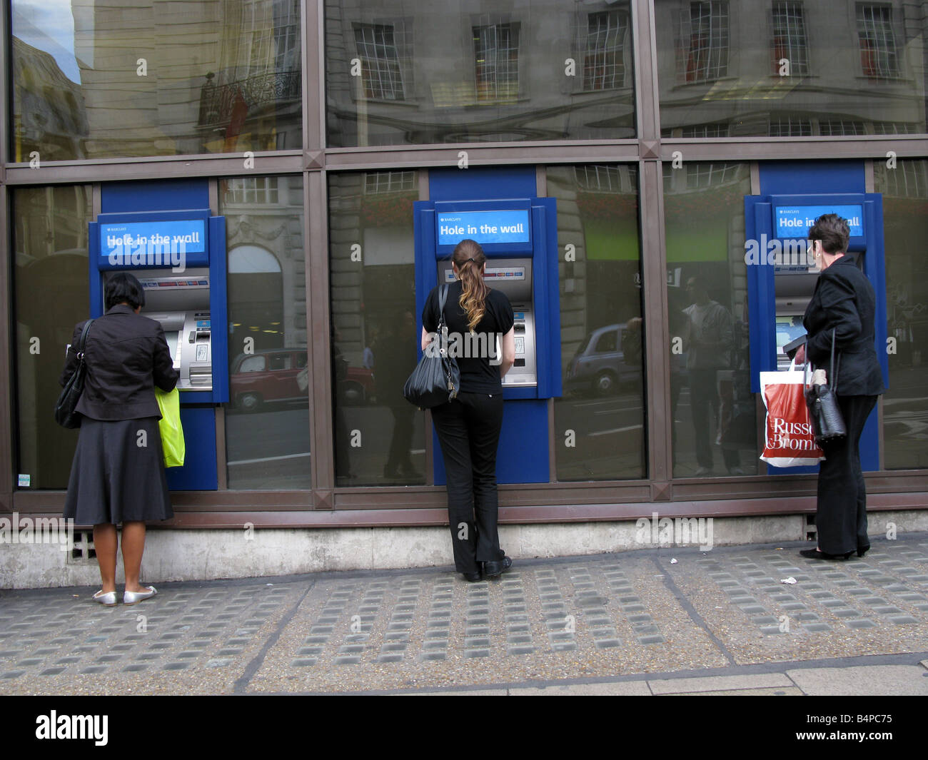 People withdrawing money from ATM, London, UK Stock Photo