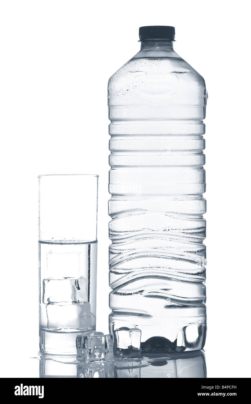 Bottle and glass of mineral water with ice cubes reflected on white ...