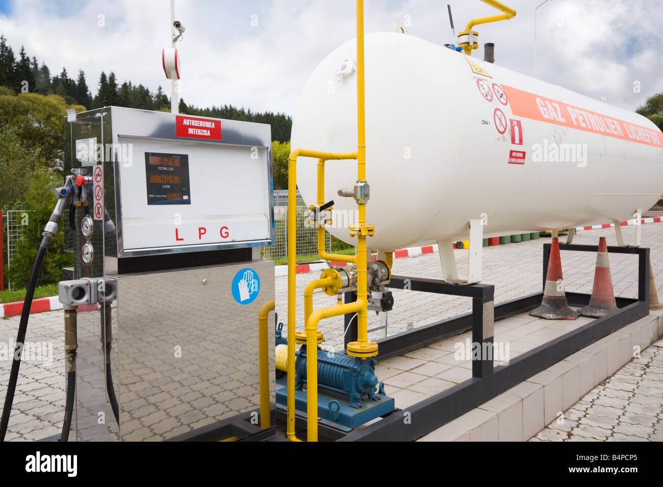 Romania Europe Fuel pump by large tank of Liquid Petroleum Gas LPG on filling station forecourt Stock Photo