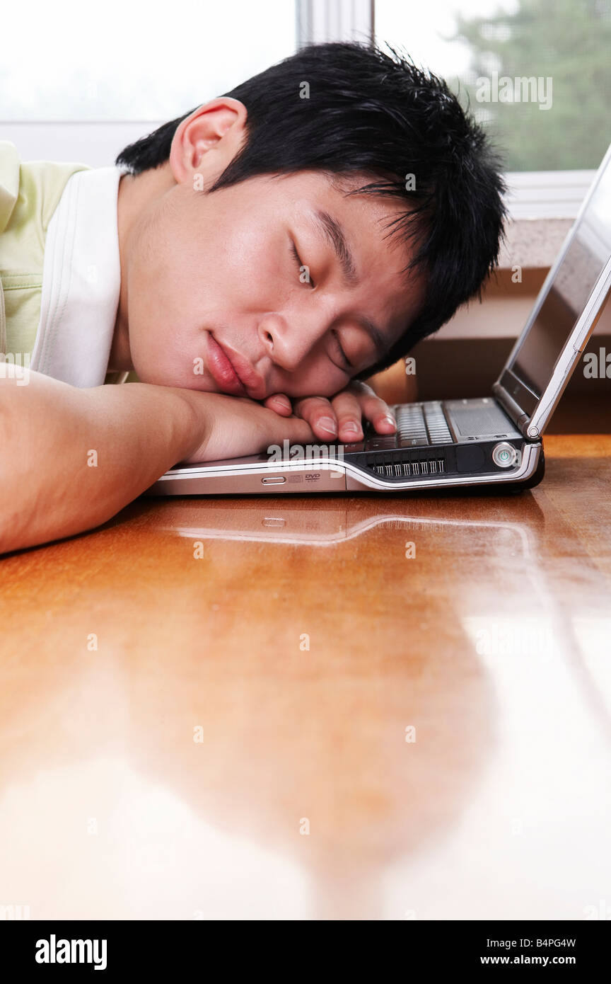 Young man sleeping face down on laptop Stock Photo Alamy