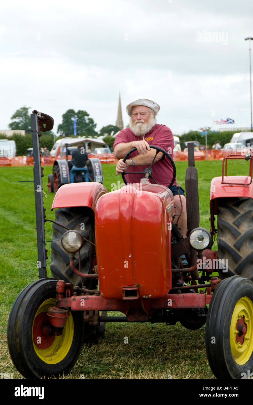 A bearded enthusiast with his vintage tractor and side mower parade at