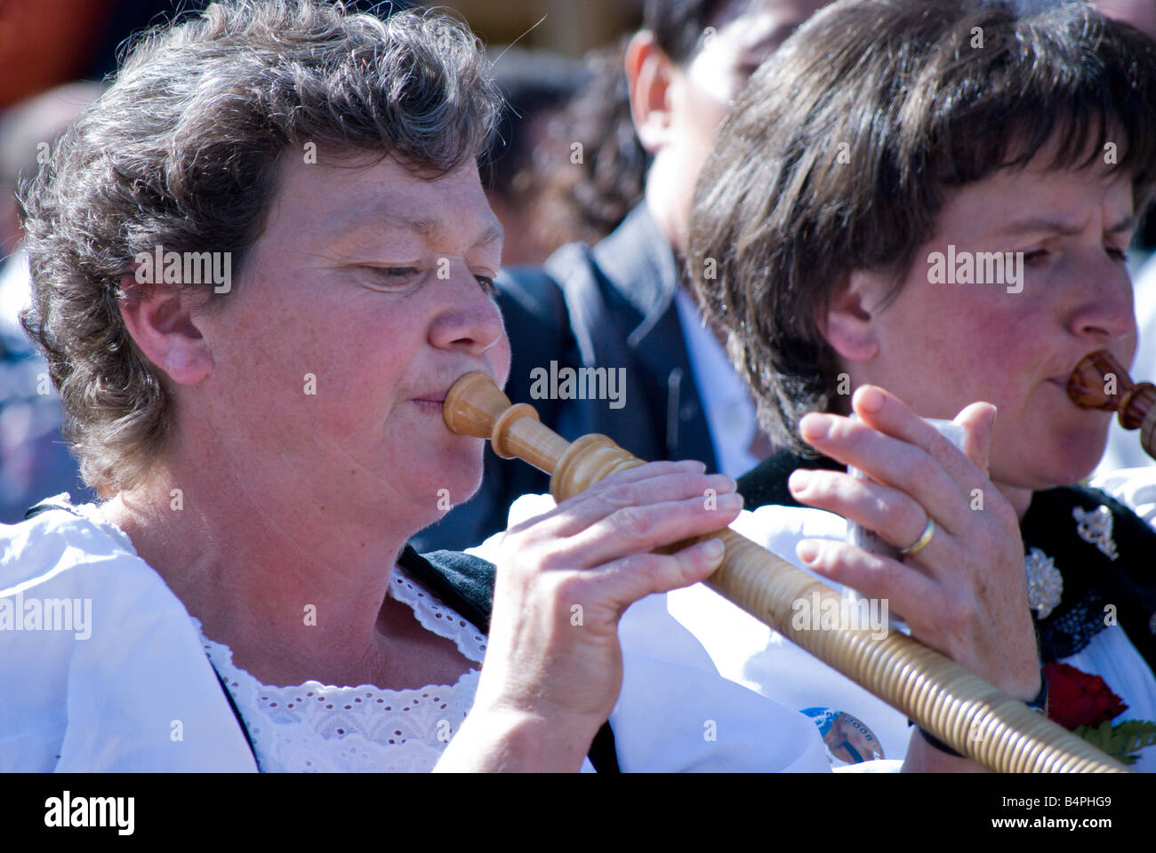 Close up of two women playing Alphenhorns at the annual Alpenfest; Lenk, Switzerland. Stock Photo