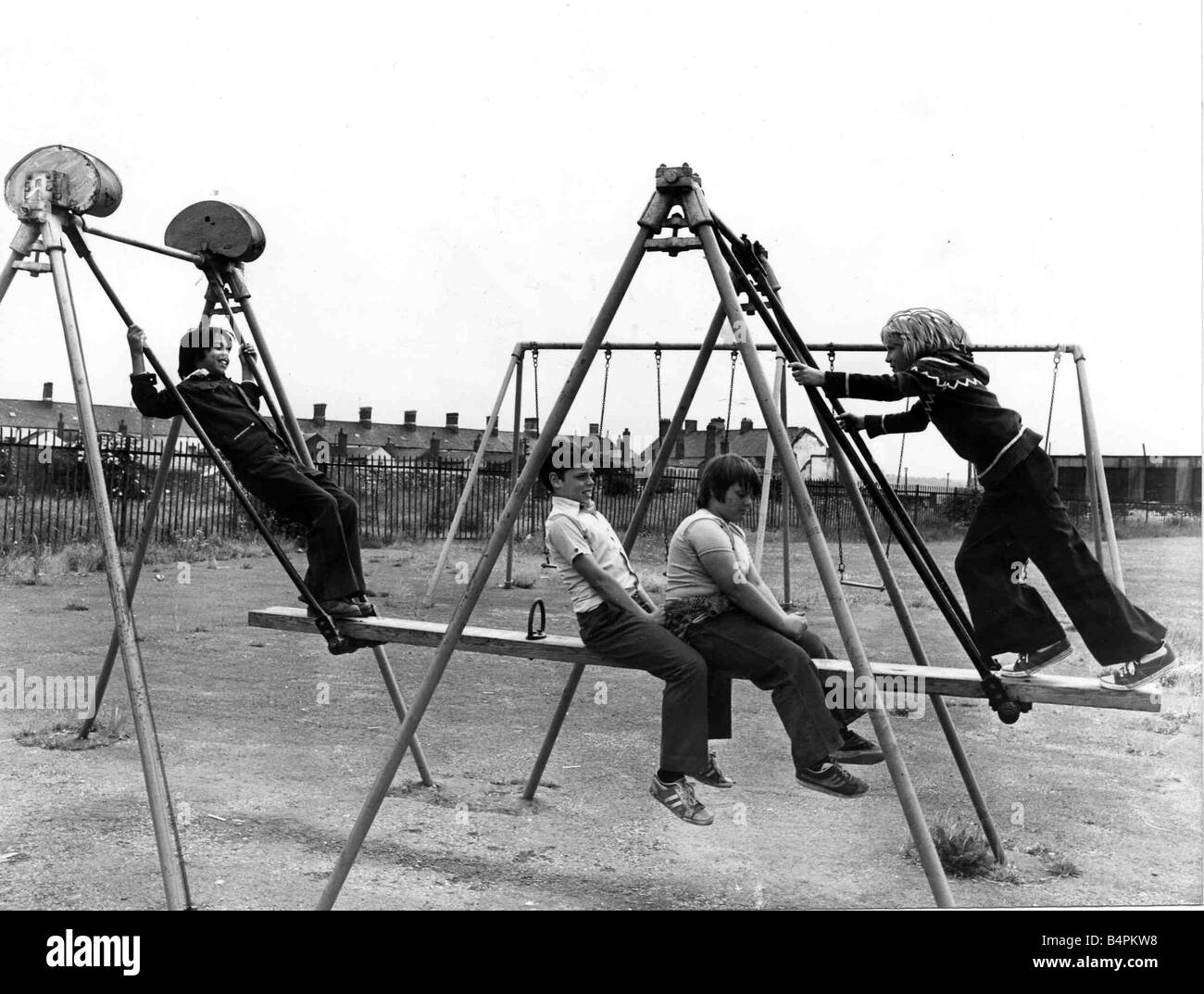 Four youngsters enjoying the Summer sunshine at a play area in the Cardiff docks area Pictured on the swinging plank are Lto R Alan Rahman Andrew Cox aged 11 Ian Morgan aged 10 and Nils Arnesen Circa 1975 Stock Photo