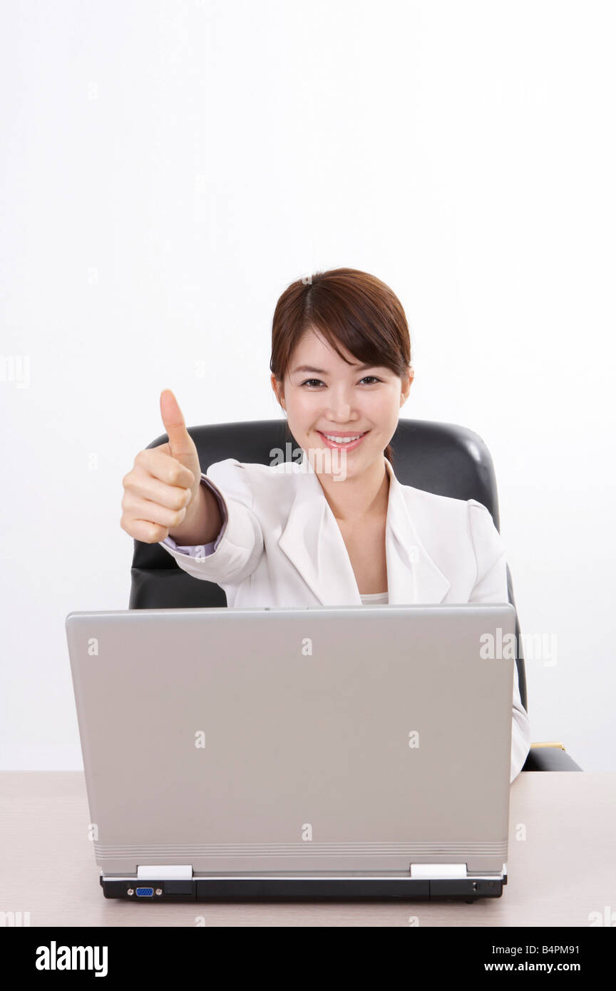 Cheerful businesswoman with laptop and thumbs up sign Stock Photo - Alamy