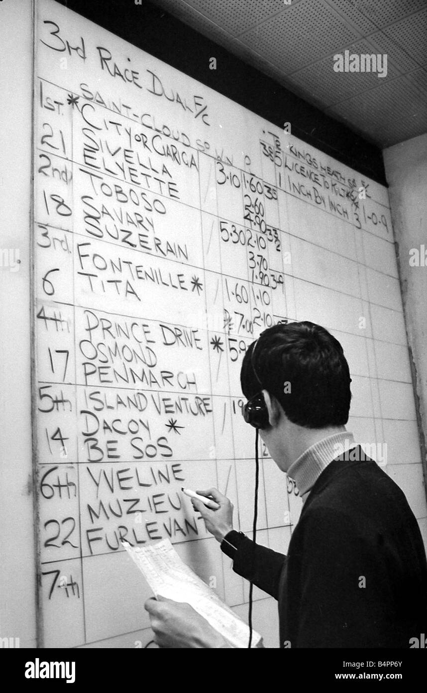 The results of the racing at Saint Cloud in Paris are marked on the board at Ladbrokes betting shop December 1967 Stock Photo