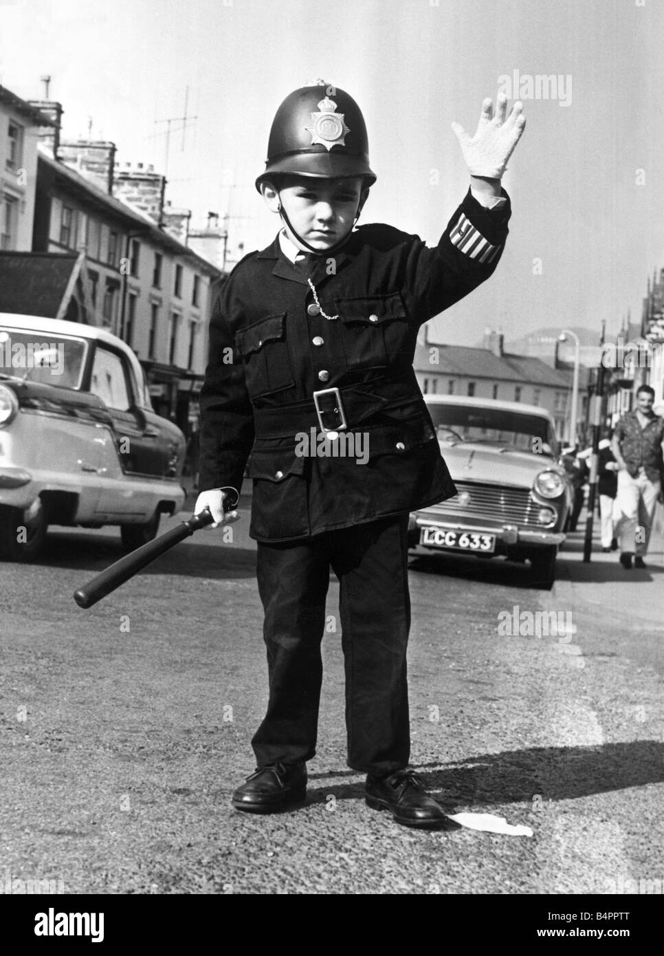 Clive Roberts of Portmadoo North Wales was given the uniform at Christmas and thinks being a policeman is wonderful Clive accompanies Special Constable Griff Lewis on traffic duty in the town s main street Octboer 1964 Stock Photo