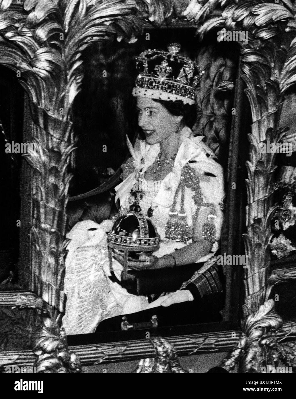 Queen Elizabeth II Coronation 1953 The Queen riding along in the coronation coach wearing crown and carrying orb Stock Photo