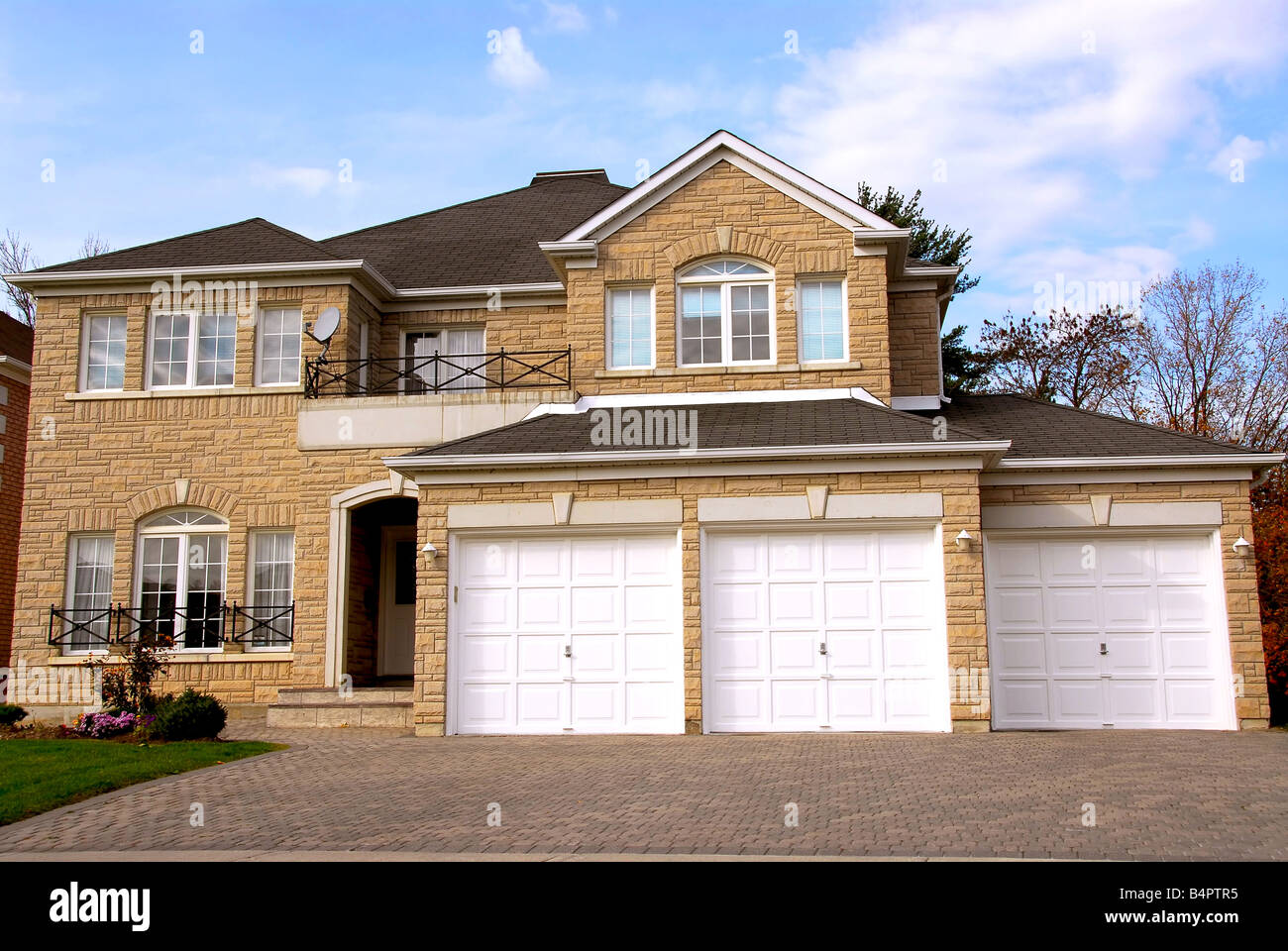 New detached single family luxury home with stone facade and tripple garage Stock Photo