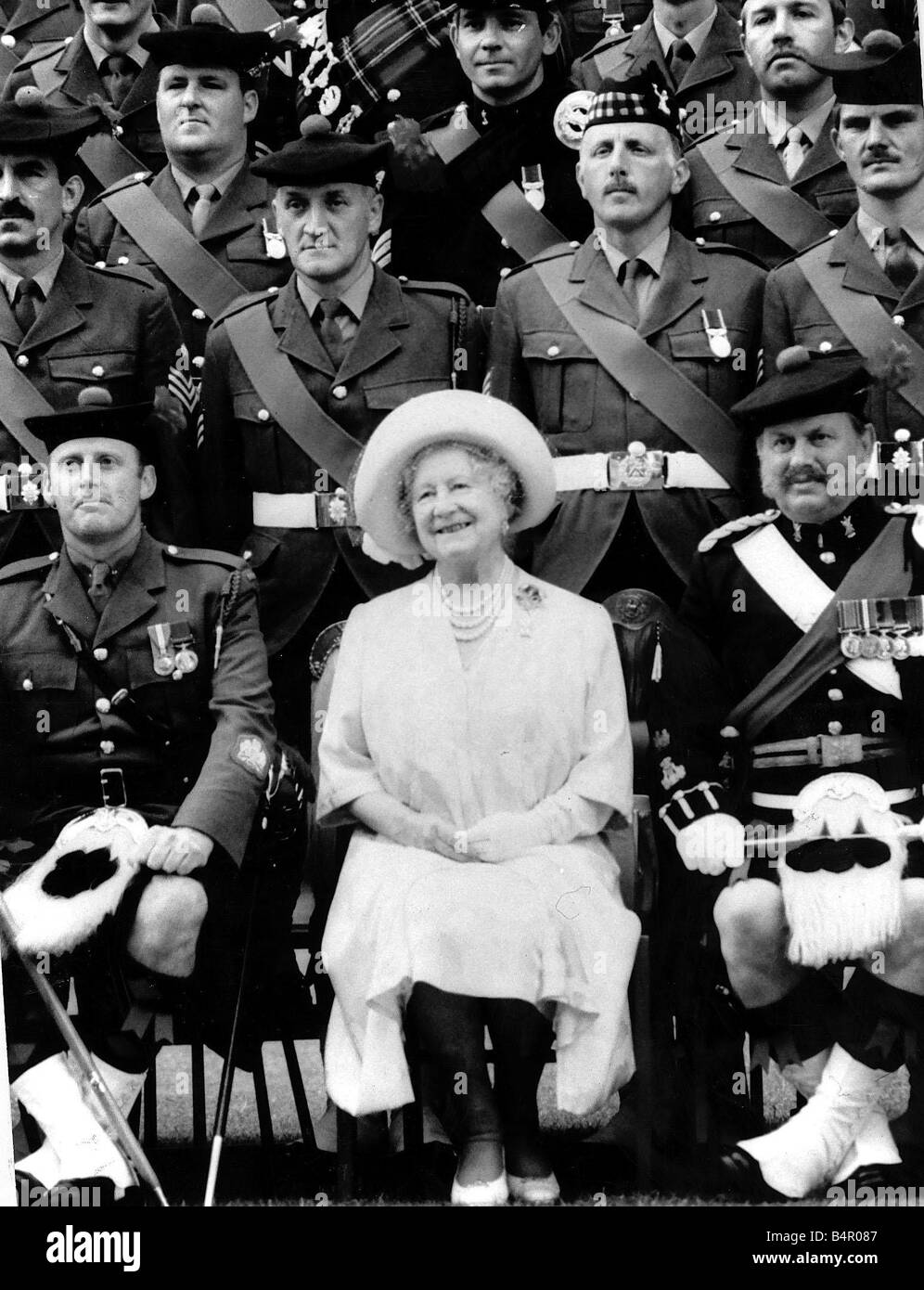 Queen Mother sitting with soldiers of the 1st Battalion 51st Highland Volunteers Stock Photo