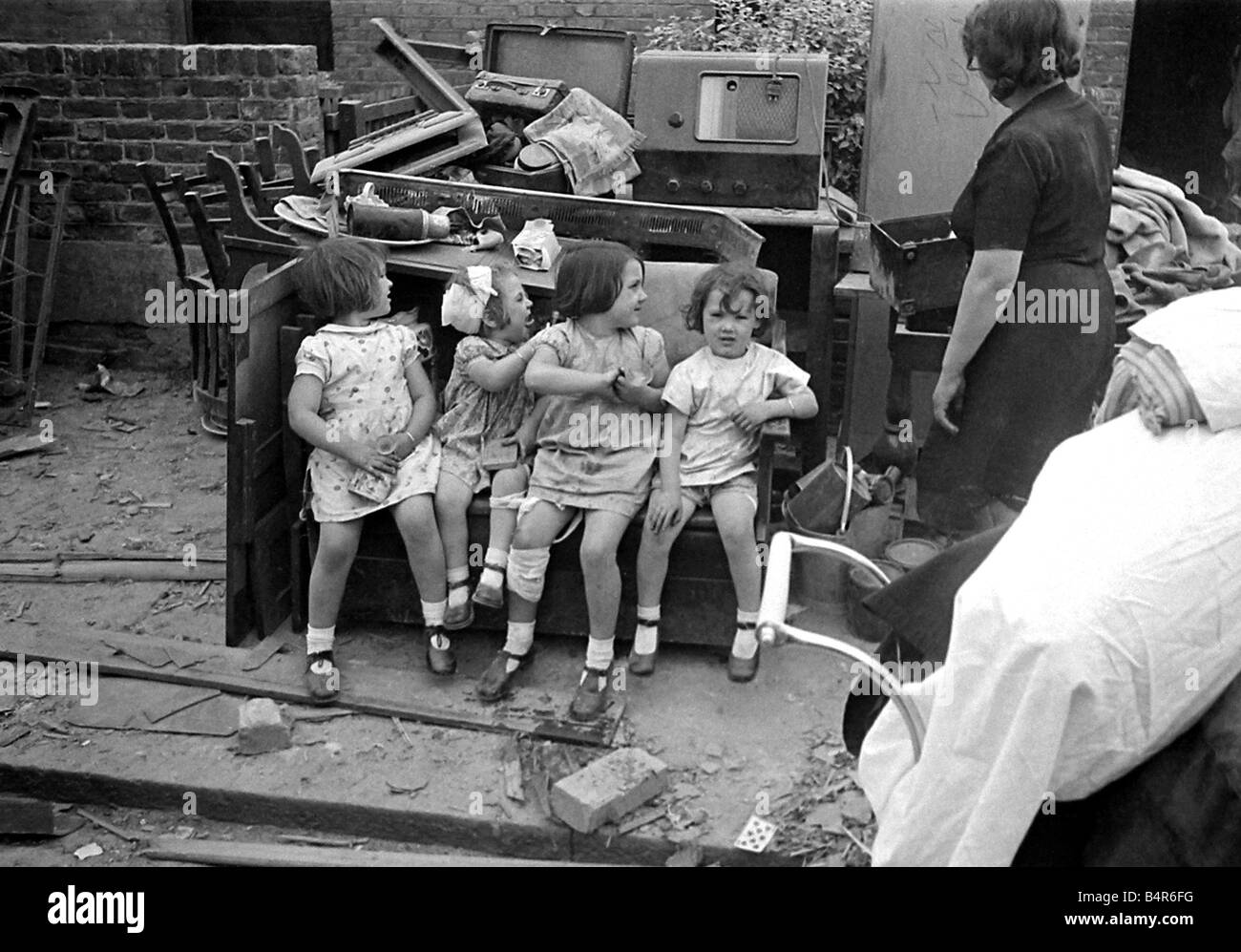 Mrs Rayner and children surrounded by bomb damage on St Mary s Road Edmonton July 1944 Stock Photo