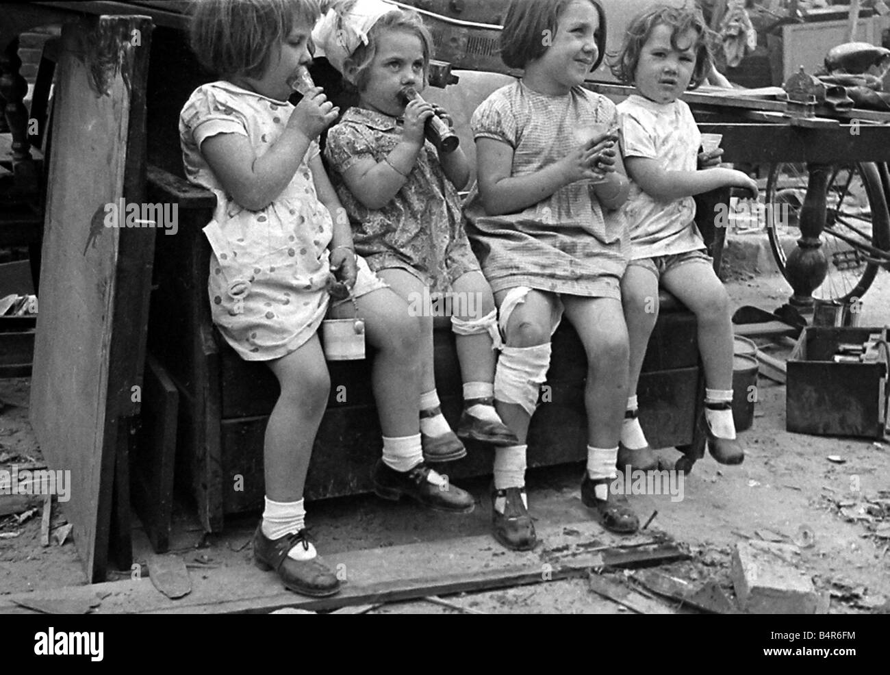 Young children surrounded by bomb damage on St Mary s Road Edmonton July 1944 Stock Photo