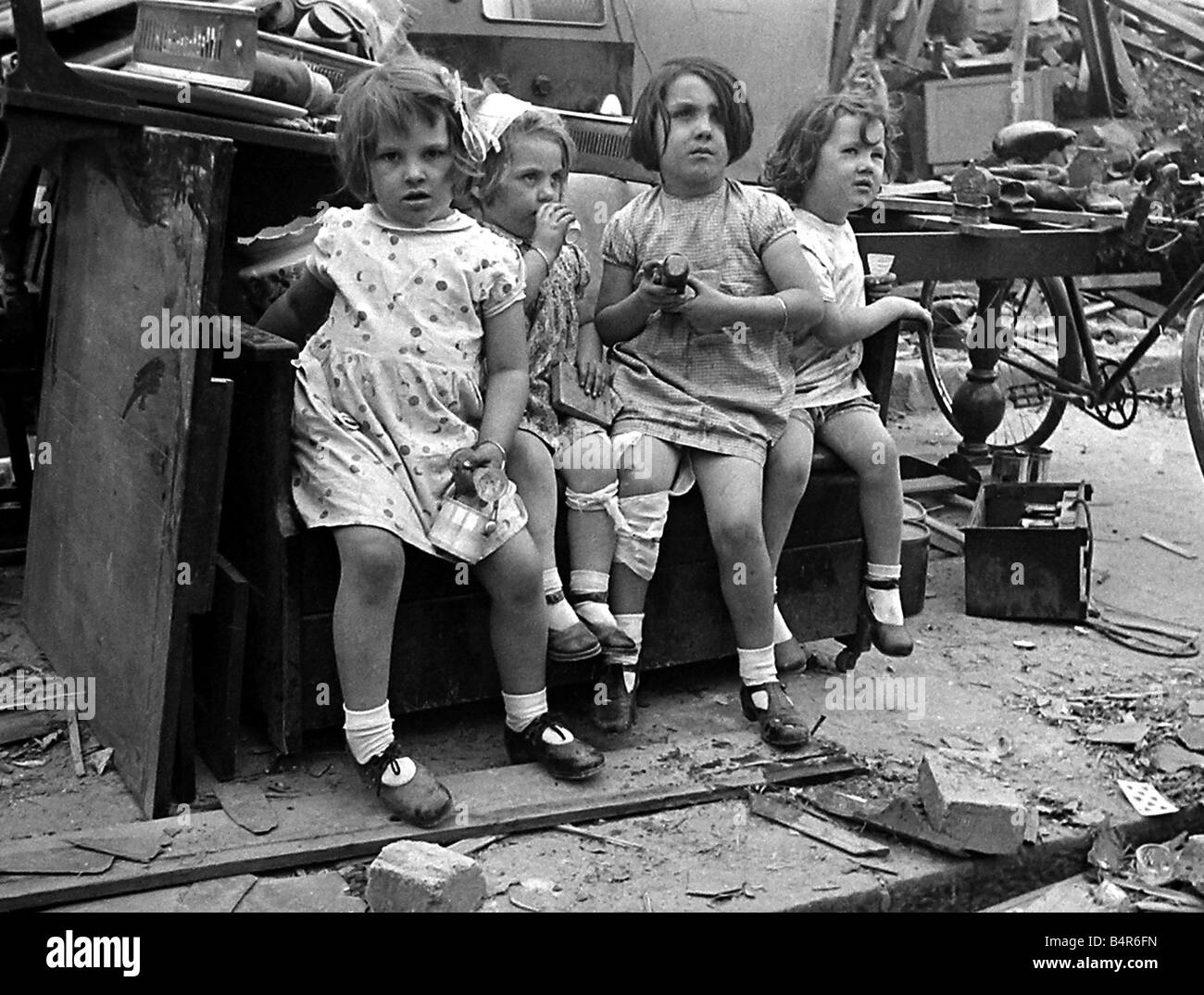 Young children surrounded by bomb damage on St Mary s Road Edmonton July 1944 Stock Photo