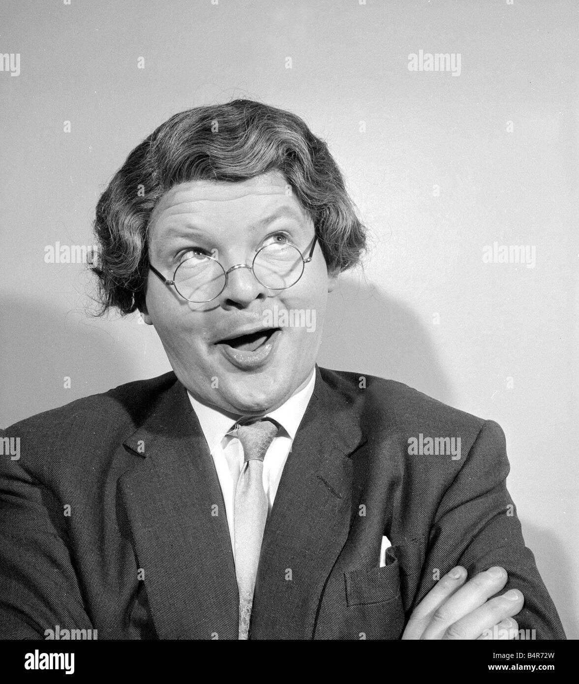 Comedian Benny Hill pictured at home wearing a wig and glasses May 1958 Stock Photo