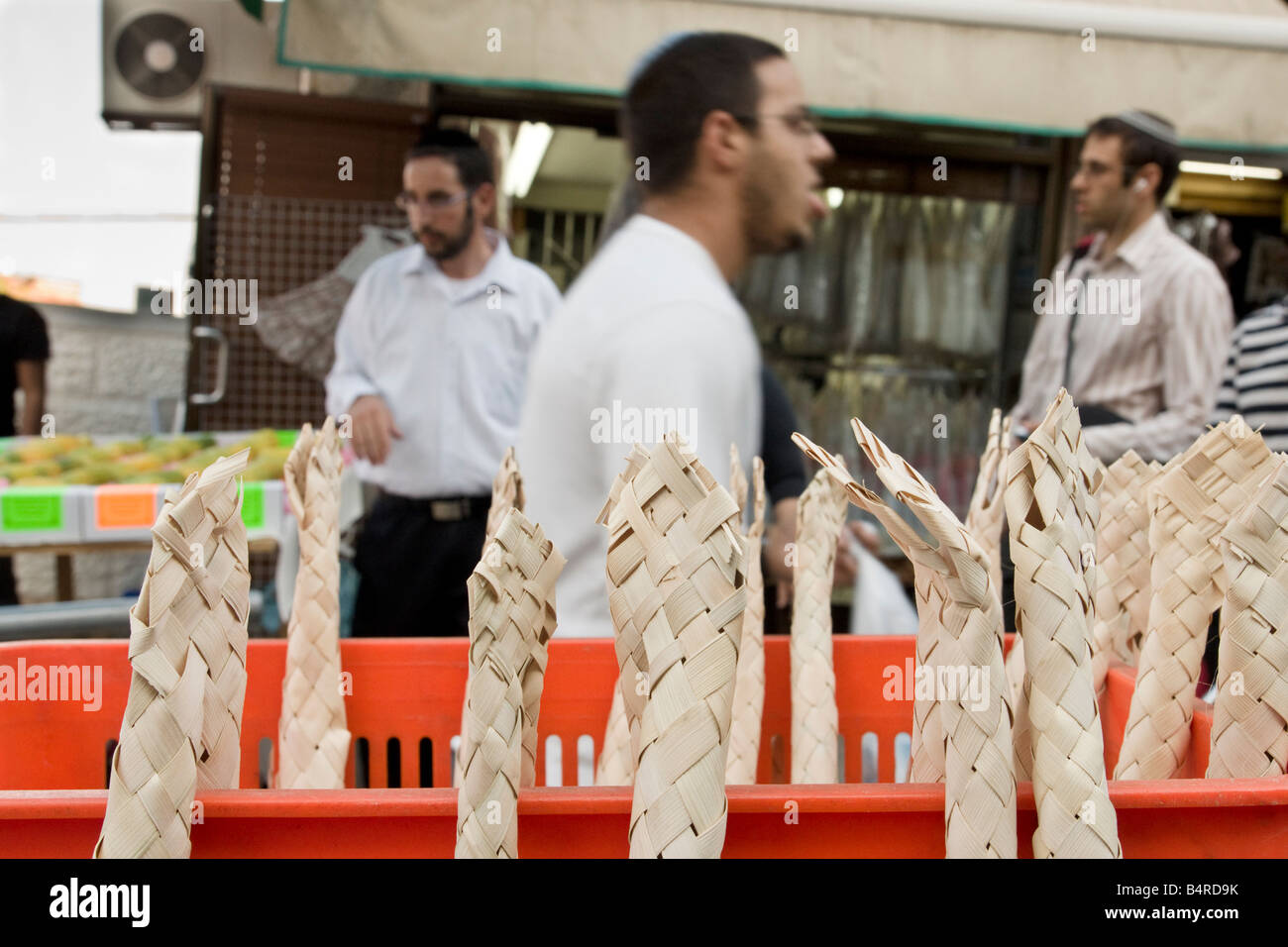 Jerusalem, Israel. People pass by interwoven dry palm leaves, used in a ritual during the Jewish Holiday of Sukot. Stock Photo