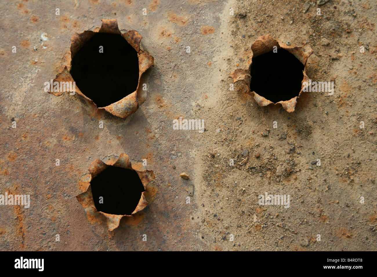 Bullet holes with black center in the iron rusty plate Stock Photo